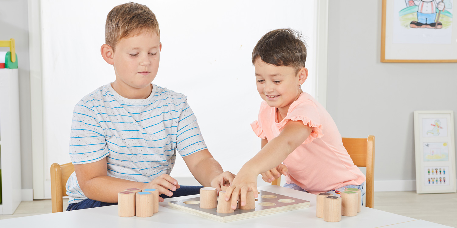Zwei Kinder spielen gemeinsam mit den Gewichten und versuchen die Gewichts-Paare herauszufinden.