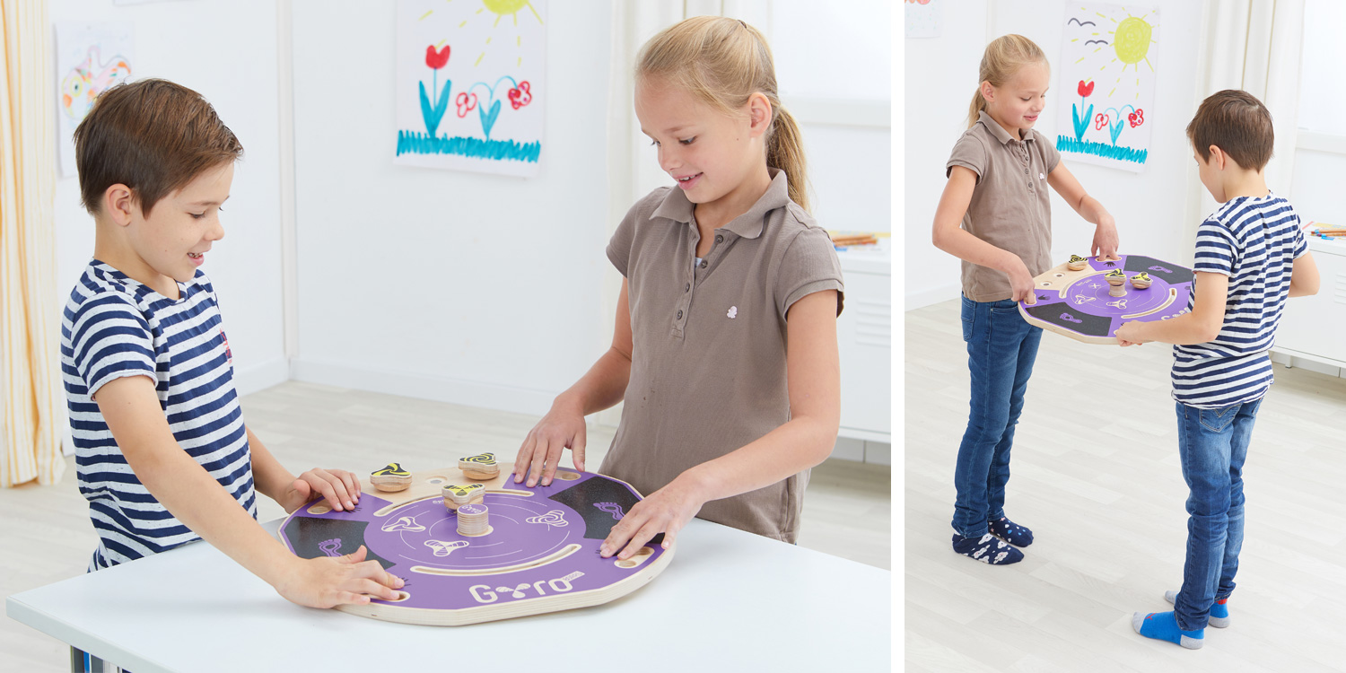 2 Kinder bringen den Magnetkreisel in Bewegung, indem sie das Board gemeinsam kippen.