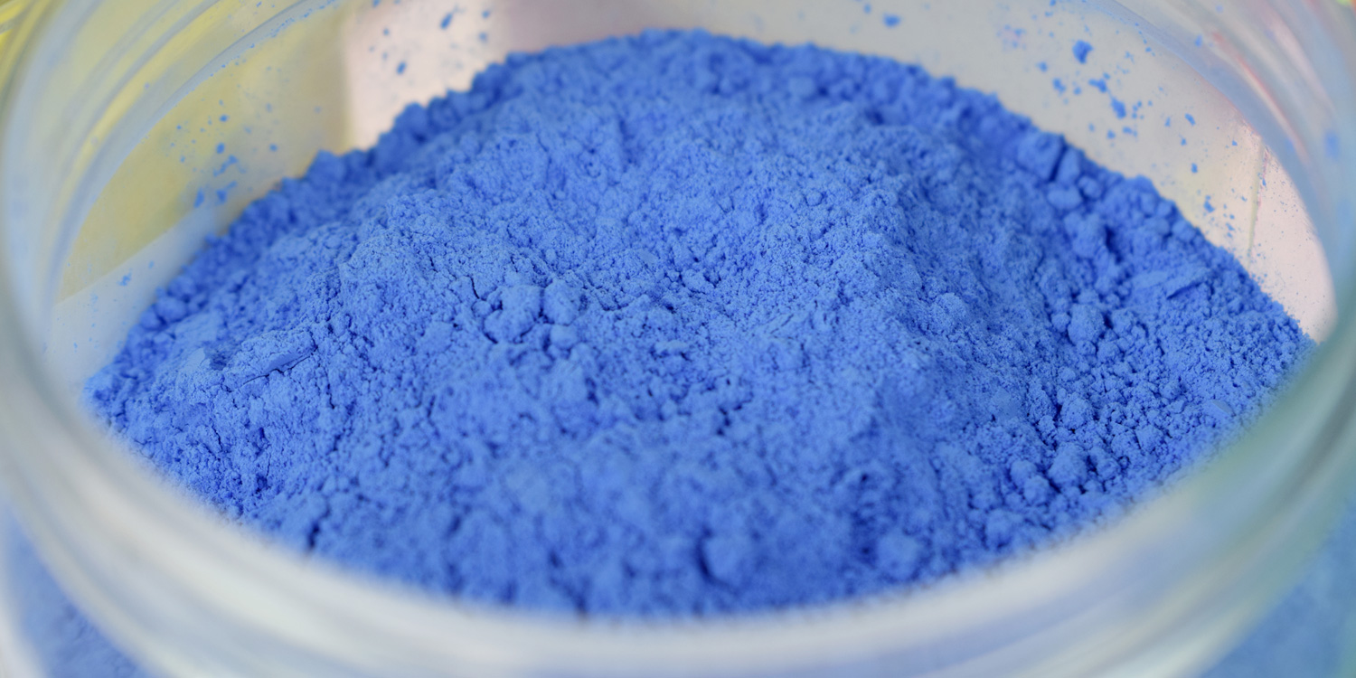 Nahaufnahme des trockenen Pulvers in der Farbe blau in der aufgeschraubten Farbdose. Das Pulver ist trocken und geschützt in der Dose.
